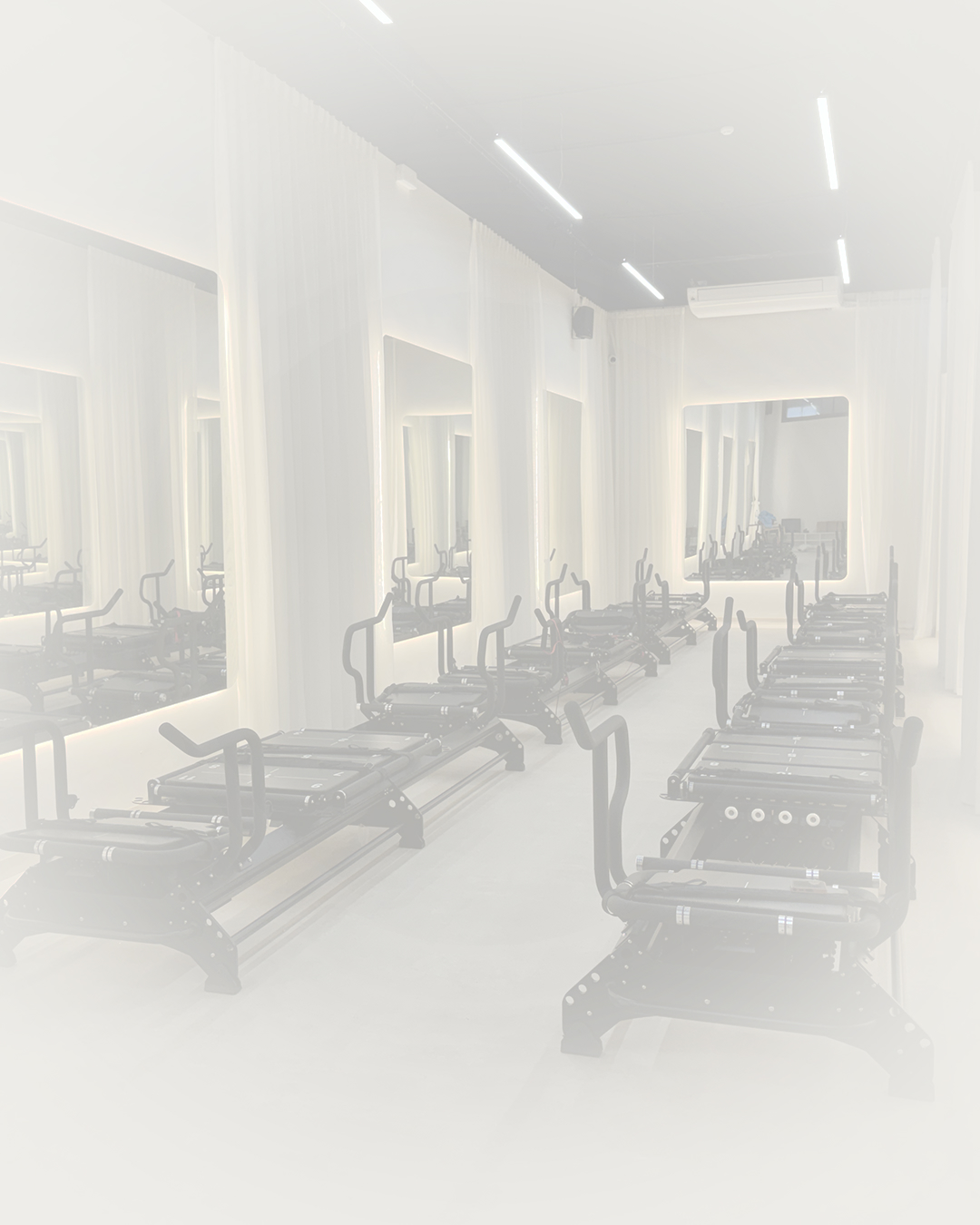La salle MEGA du studio Powerformer, alignée de machines Reformer face aux miroirs